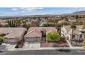 An aerial view of a single-story home with a tile roof, surrounded by other homes and mountains in the distance at 10563 Sunblower Ave, Las Vegas, NV 89135