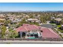Expansive aerial view of the luxury property showcasing the tile roof, pool, and landscaped yard at 2101 Strada Mia Ct, Las Vegas, NV 89117
