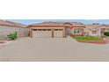 Beige single-story home featuring a spacious driveway, desert landscaping and a terracotta tile roof at 4322 Summers Shade St, Las Vegas, NV 89147