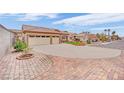 Beige single-story home featuring a spacious driveway, desert landscaping and a terracotta tile roof at 4322 Summers Shade St, Las Vegas, NV 89147