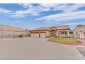 Beige single-story home featuring a spacious driveway, desert landscaping and a terracotta tile roof at 4322 Summers Shade St, Las Vegas, NV 89147