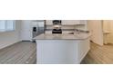 Kitchen island with a sink, stone countertops and white cabinets at 4790 Equinox Sky Ave # 2, North Las Vegas, NV 89084