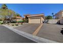 Exterior of a home with a terracotta roof and large paved driveway with a gated side entrance at 4936 Mountain Foliage Dr, Las Vegas, NV 89148