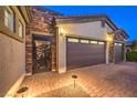 A three-car garage featuring a brick facade and custom door at 5640 Willow Canyon St, Las Vegas, NV 89149