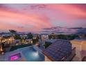 Stunning aerial view of the backyard pool and spa, showcasing city views and neighborhood at dusk at 640 Hayborn Meadows St, Las Vegas, NV 89138