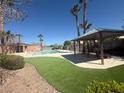 Community pool with shaded seating area, palm trees, and pristine landscaping at 6546 Churnet Valley Ave, Las Vegas, NV 89139