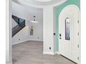 Bright foyer showcasing modern lighting, wood-look floors, and staircase in a contemporary design at 7695 Windy Meadow Ave, Las Vegas, NV 89178