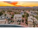 Beautiful aerial view of a neighborhood with palm trees and mountain backdrop at sunset at 784 Tossa De Mar Ave, Henderson, NV 89002