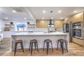Bright, modern kitchen with stainless steel appliances, marble countertops, and a large island with seating at 8645 Edmond St, Las Vegas, NV 89139