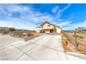 Two-story home showing the front yard, concrete driveway and desert landscaping under a blue sky at 9010 W Lone Mountain Rd, Las Vegas, NV 89129