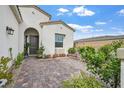 Inviting front courtyard with lush greenery, a brick-paved patio and comfortable seating at 10196 Millholm Ave, Las Vegas, NV 89166