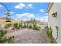 Charming patio area with brick pavers, outdoor seating, and lush greenery at 10196 Millholm Ave, Las Vegas, NV 89166