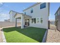 Well-maintained backyard featuring a covered patio, artificial grass, and privacy fence at 10214 Natural Anchor St, Las Vegas, NV 89166