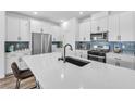 Modern kitchen with white cabinetry, stainless steel appliances, and a large center island with sink at 10214 Natural Anchor St, Las Vegas, NV 89166