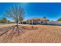 Lovely single-story home showcasing a manicured front yard, three-car garage, and a welcoming entrance with columns at 1131 China St, Pahrump, NV 89048