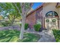 Beautifully landscaped front yard with mature trees leading to a charming home entrance at 1853 Heydon Ct, Henderson, NV 89014