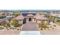 Expansive view of a well-manicured property featuring a solar-paneled roof, desert landscaping, and a luxurious pool at 274 Chartan Ave, Las Vegas, NV 89183