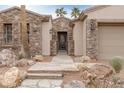 Inviting home entrance with a stone pathway, manicured bushes, and decorative stone accents at 2822 Soft Horizon Way, Las Vegas, NV 89135