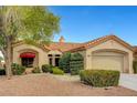 Inviting single-story home featuring a lush landscaped front yard, red awning, and tile roof at 3020 Ripon Dr, Las Vegas, NV 89134