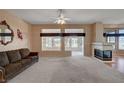 Bright living room with plush carpet, fireplace, and large windows providing natural light at 3020 Ripon Dr, Las Vegas, NV 89134