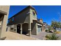 Home featuring an arched porch leading to the front door, two-car garage, and desert landscaping at 3820 Ramura Ave, North Las Vegas, NV 89084