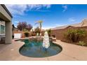 Inviting pool area with a relaxing spa, surrounded by palm trees and an umbrella for shade at 3920 Eiderdown Pl, North Las Vegas, NV 89084
