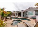 Backyard featuring a sparkling pool, jacuzzi, and lounge chairs for relaxing, surrounded by mature landscaping at 3920 Eiderdown Pl, North Las Vegas, NV 89084