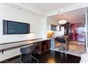 Inviting living area with sleek black desk and a TV, with a view to the convenient stainless steel kitchen at 4381 W Flamingo Rd # 2605, Las Vegas, NV 89103