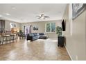 Open-concept living room boasts neutral colors, a ceiling fan, and ample natural light from a large window overlooking the backyard at 5614 Bishop Flowers St, Las Vegas, NV 89130