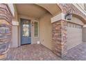 Inviting front porch with stone accents, decorative door, and brick-paved walkway leading to the entrance at 5671 Camilla Cellars Ct, Las Vegas, NV 89141