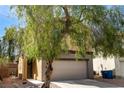 Cozy home with a desert landscape, a mature shade tree, and an attached two car garage at 6745 Jackson Junction St, Las Vegas, NV 89149