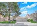 Charming single-story home features a red tile roof, attached two-car garage and a well-manicured front yard at 7405 Blue Sage Ct, Las Vegas, NV 89129