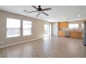 Open living space with wood-look flooring, ceiling fan and sliding glass doors at 7826 Shingle Beach St, Las Vegas, NV 89166