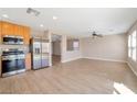 Open-concept kitchen and living area with modern stainless steel appliances at 7826 Shingle Beach St, Las Vegas, NV 89166