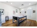 Bright game room with hardwood floors, featuring an air hockey table and natural light from arched windows at 792 Valley Rise Dr, Henderson, NV 89052