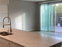 Modern kitchen with stainless steel sink, quartz countertops, and a view to the backyard at 9343 Sully Ave, Las Vegas, NV 89149
