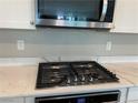 Gourmet kitchen featuring gas cooktop, quartz countertop and stainless steel microwave at 9343 Sully Ave, Las Vegas, NV 89149