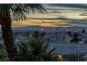 Gorgeous morning view of the Las Vegas skyline and distant mountains framed by mature palms at 979 Evening Dew Dr, Las Vegas, NV 89110