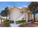 Charming condo exterior with well-maintained landscaping, mature trees, and private stairways at 10100 Jacob Pl # 204, Las Vegas, NV 89144