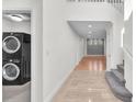 Hallway with tile floors, stairs, and a laundry area at 10955 Sospel Pl, Las Vegas, NV 89141
