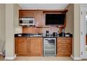 A compact kitchenette features wooden cabinets, modern appliances, and a sleek countertop at 135 E Harmon Ave # 405, Las Vegas, NV 89109