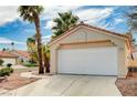 Attached garage with a white door and a concrete driveway in front of a charming home at 1645 Indian Cove Ln, Las Vegas, NV 89128