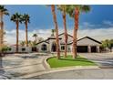 A beautiful, desert home featuring a circle driveway, well-maintained landscaping and lush palm trees at 167 Ebb Tide Cir, Las Vegas, NV 89123
