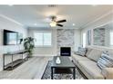 Open living room featuring a decorative stone fireplace, ceiling fan, large window, and comfortable seating area at 1701 E Katie Ave # 9, Las Vegas, NV 89119