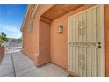 A close up of the main entrance to the home, featuring a white security screen door and decorative light fixture at 1951 Raspberry Hill Rd, Las Vegas, NV 89142