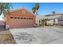 Single Gathering home featuring a two-car garage with a wide concrete driveway and desert landscaping at 1951 Raspberry Hill Rd, Las Vegas, NV 89142