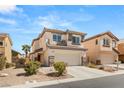 Charming two-story home with neutral stucco, a two-car garage, and drought-tolerant landscaping at 232 Dog Leg Dr, Las Vegas, NV 89148