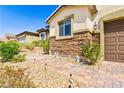 Beautiful home with a charming walkway, stone accents, and desert-friendly landscaping at 2612 Tullamore Creek Ln, Laughlin, NV 89029
