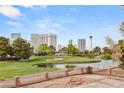 Scenic view of a golf course, pond, and the city skyline in the distance, with a brick patio in the foreground at 3207 Bel Air Dr, Las Vegas, NV 89109