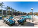 Relaxing pool area featuring an in-ground pool, lounge chairs, couches, and palm trees at 353 E Bonneville Ave # 289, Las Vegas, NV 89101